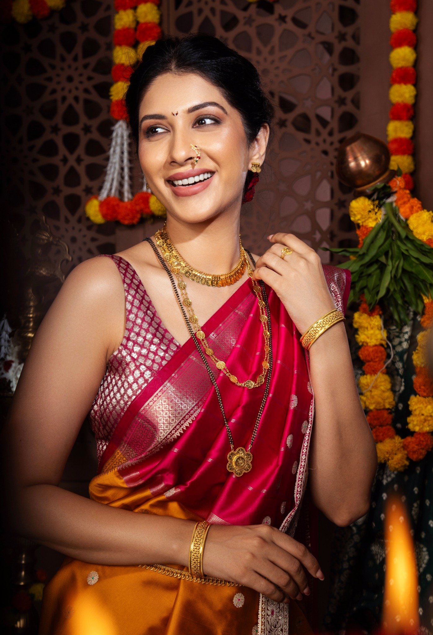 Woman in green Paithani saree and gold jewellery